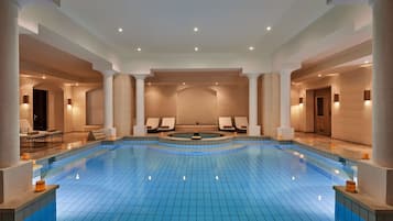 Relax by the pool in a spacious, well-lit area with a central seating area and lounge chairs.