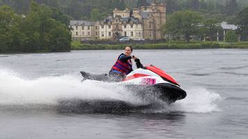 Una persona en un jet ski con el número 421, rodeada de agua salpicando.