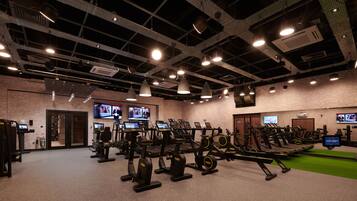 A gym with multiple treadmills, stationary bikes, and weight machines.