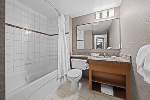 A modern bathroom with a bathtub, toilet, and vanity. - Sandman Hotel Calgary Airport (Calgary)