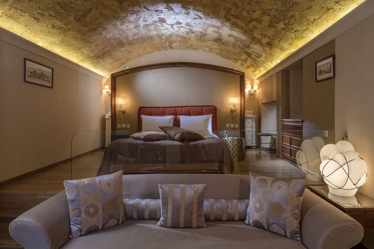 Ein Schlafzimmer mit einem großen Bett, einer Couch und einer Kristallleuchter.