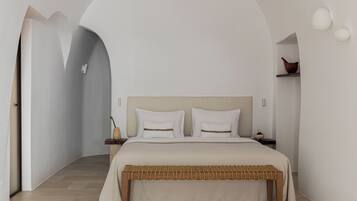 A bedroom with a bed, a nightstand, and a wall-mounted light fixture.
