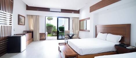 Una habitación de hotel moderna con una cama grande, un escritorio y vistas al exterior.