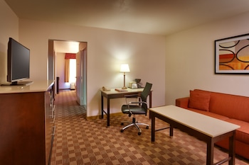 A laundry room with a dryer, washing machine, and a utility meter. at Cortona Inn & Suites Anaheim Resort