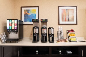 Een automaat voor drankjes met verschillende tappunten, een koffieapparaat en een presentatie van fruit.