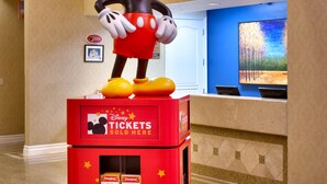 A Mickey Mouse statue on a ticket counter with a sign for Disneyland Resort. - Cortona Inn & Suites Anaheim Resort (Anaheim)