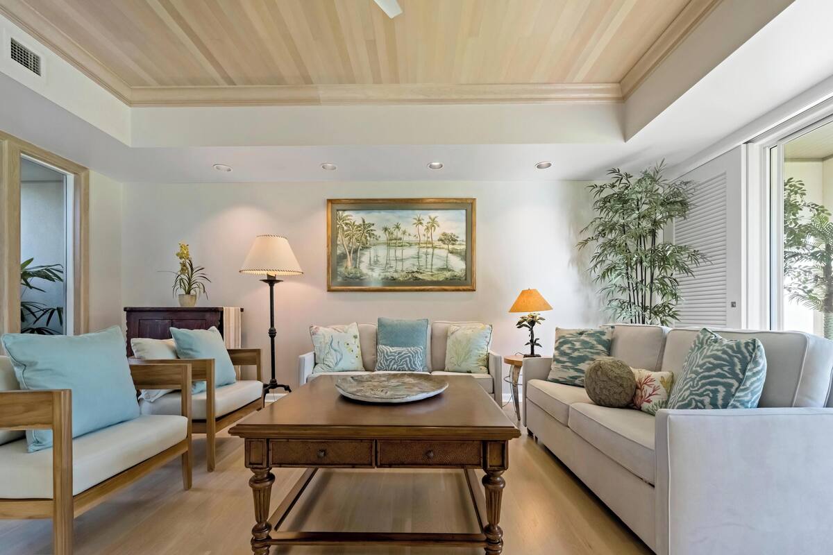 A living room with a wooden coffee table, two sofas, a floor lamp, and a painting on the wall.