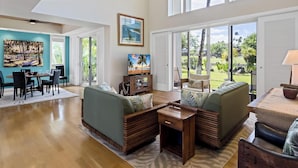 Amplia sala de estar con comedor, ventanas grandes y vistas al exterior.