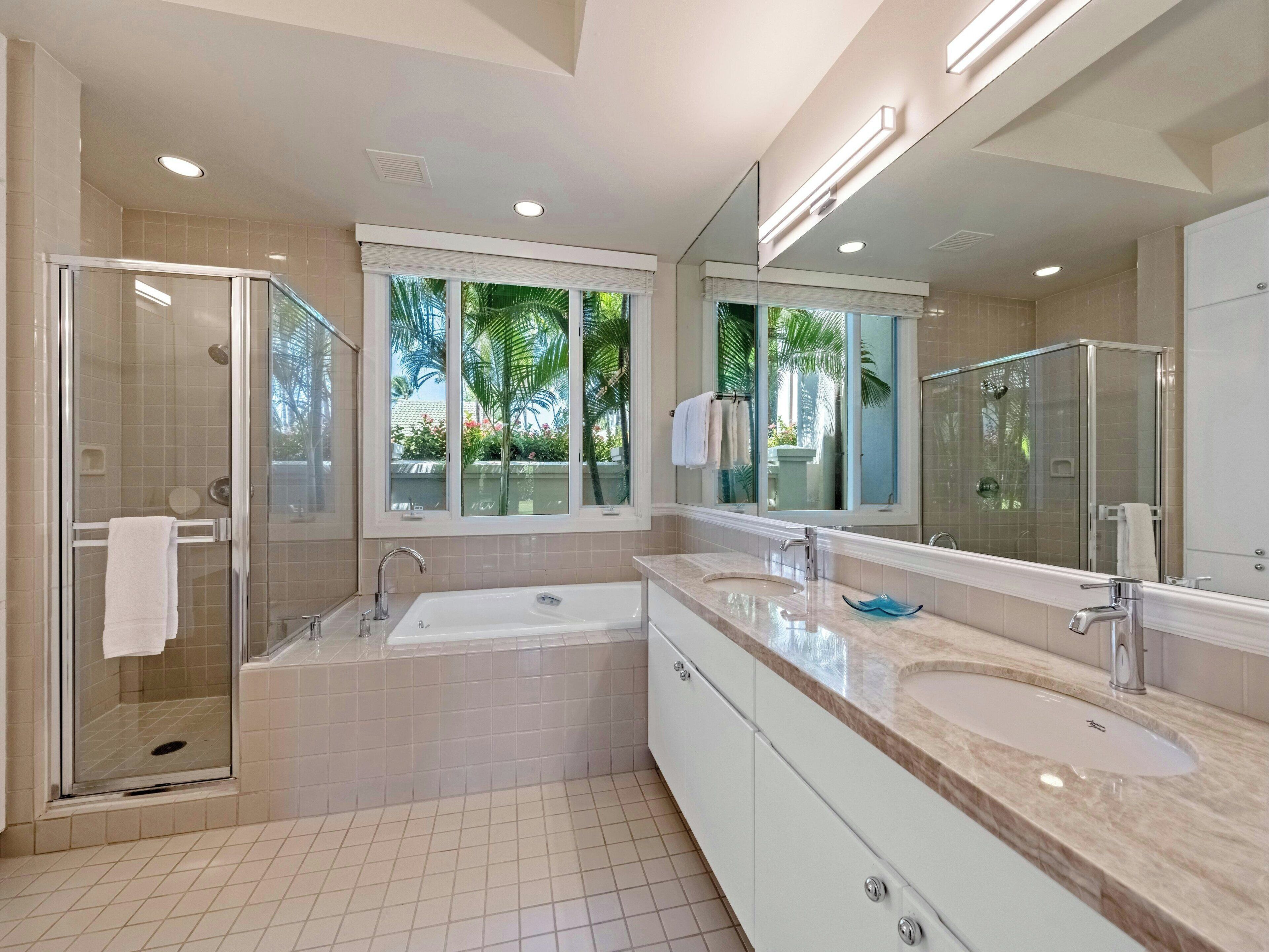 Un bagno moderno con cabina doccia in vetro, un ampio lavabo doppio e uno specchio grande.