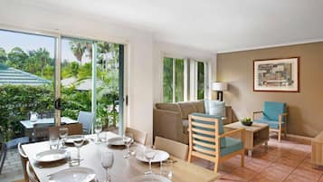 Un comedor con una mesa dispuesta para cuatro personas, un sofá y una silla.