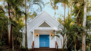 A white building with a blue door, surrounded by tropical vegetation. - BreakFree Aanuka Beach Resort (Coffs Harbour)