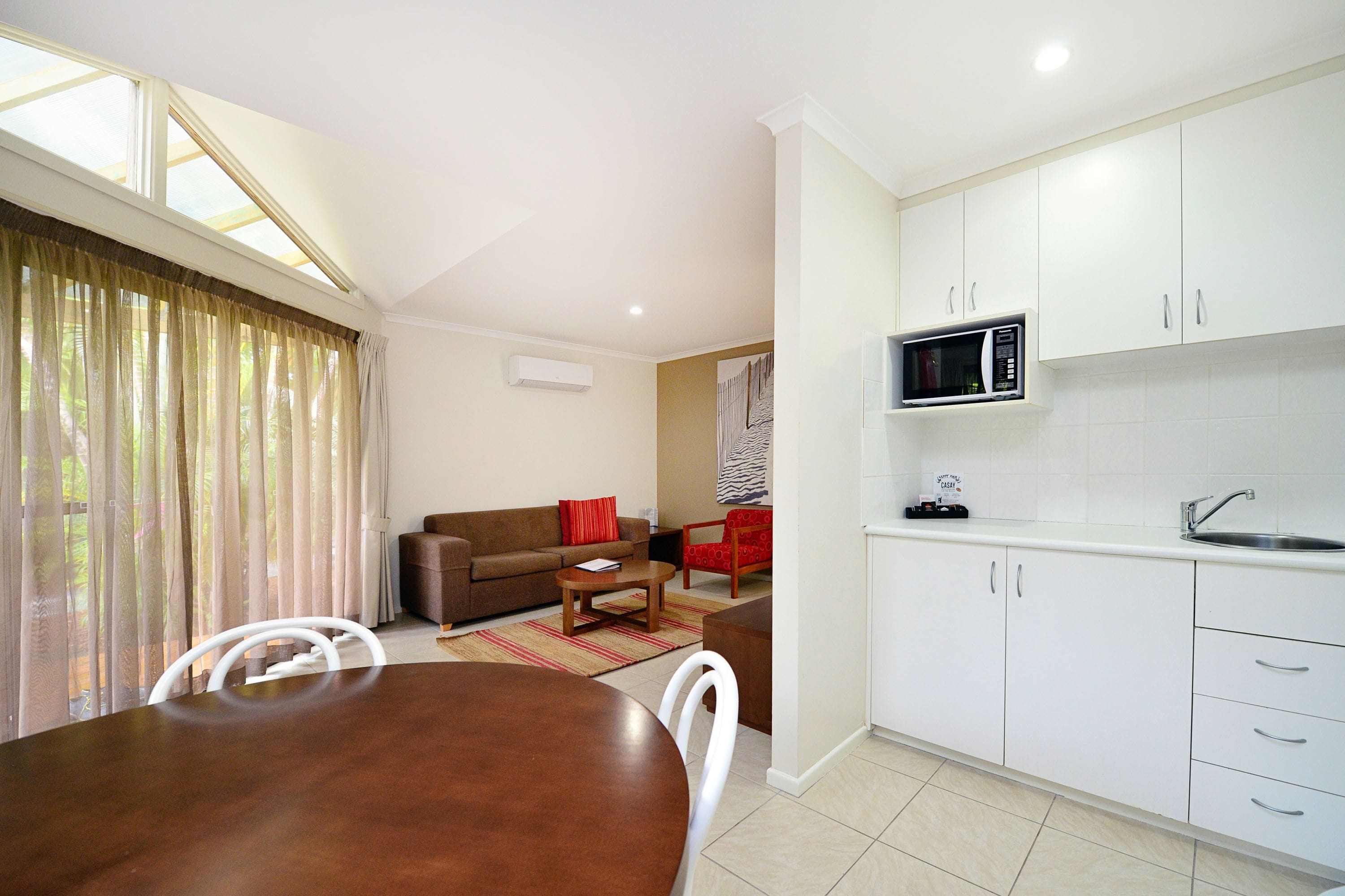 Un espacio habitable compacto con comedor, kitchenette y zona de estar.