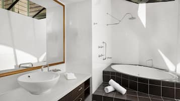 A modern bathroom with a large sink, a bathtub, and a shower.