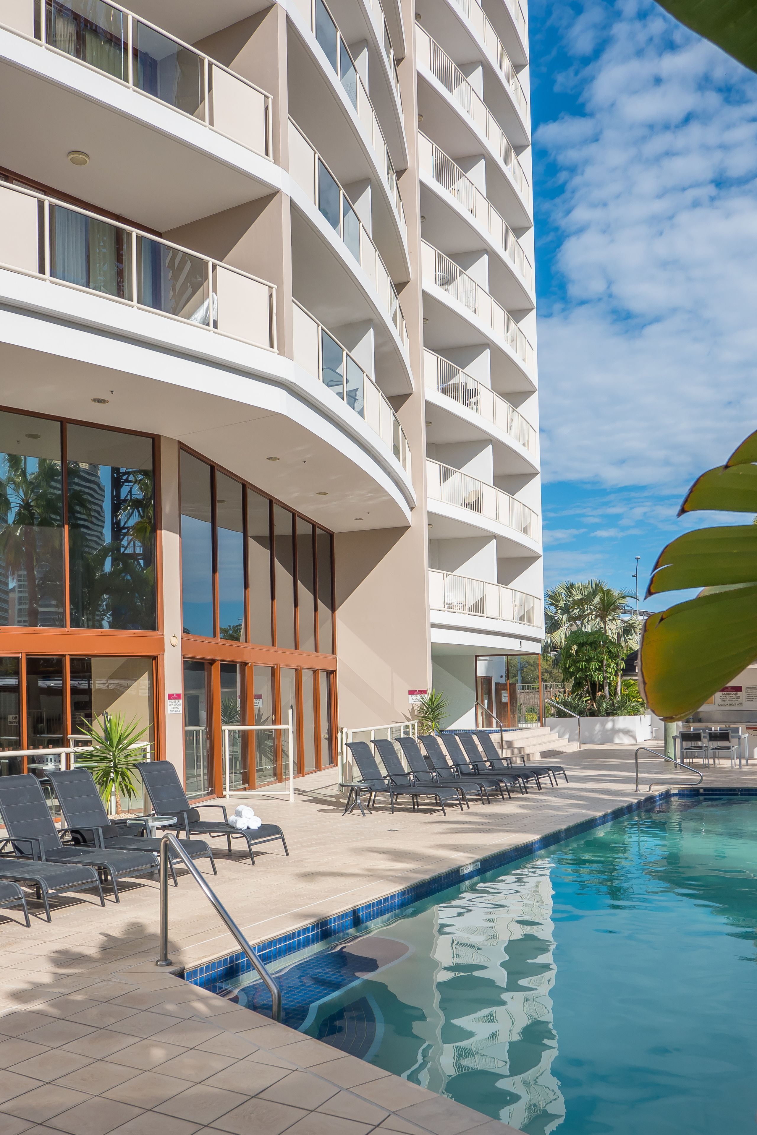 Una piscina al aire libre, sillones reclinables de piscina