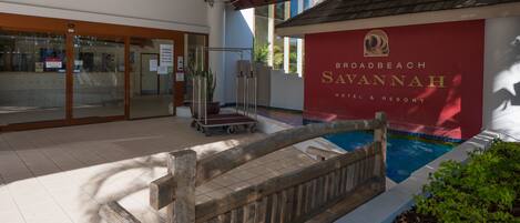 The entrance of the Roadbeach Savannah Hotel & Resort with a pool area visible.