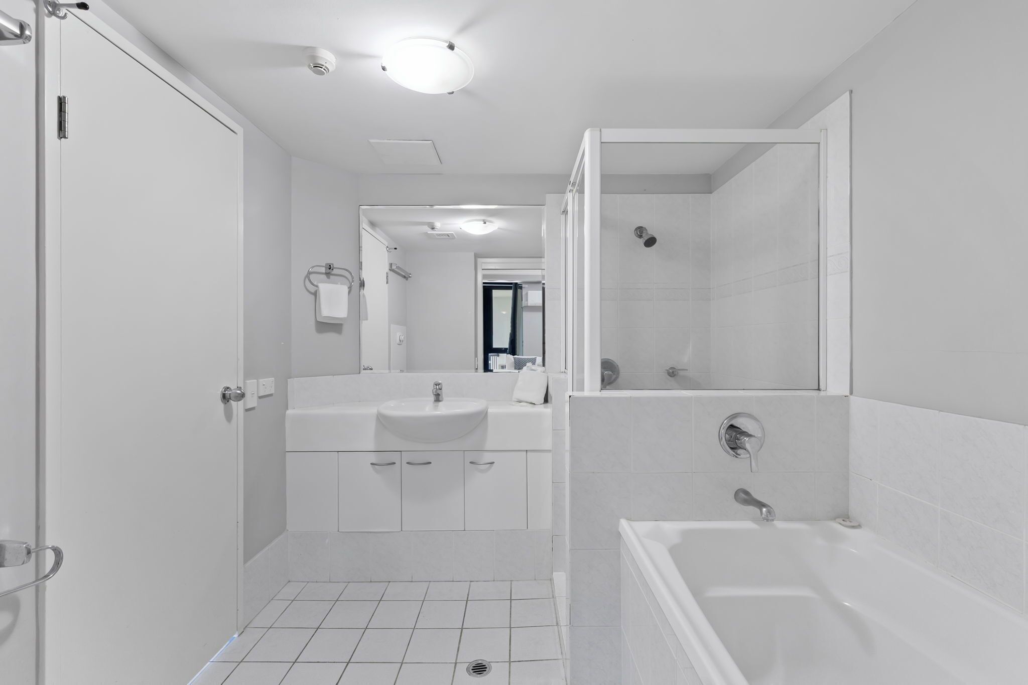 Een moderne badkamer met douche, bad en wastafel.