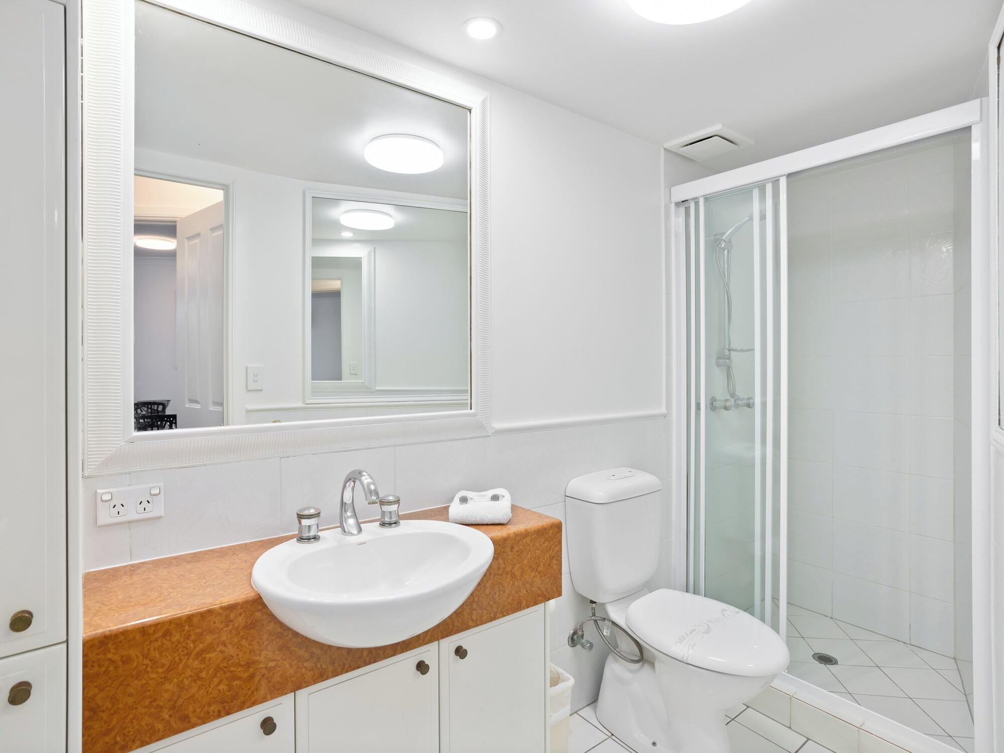 Une salle de bain moderne avec un lavabo, un meuble-lavabo et des toilettes, le tout de couleur blanche.
