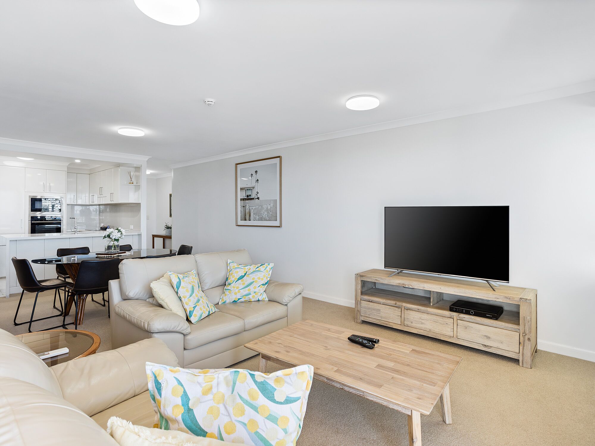 A modern living room with a sofa, coffee table, and TV stand.