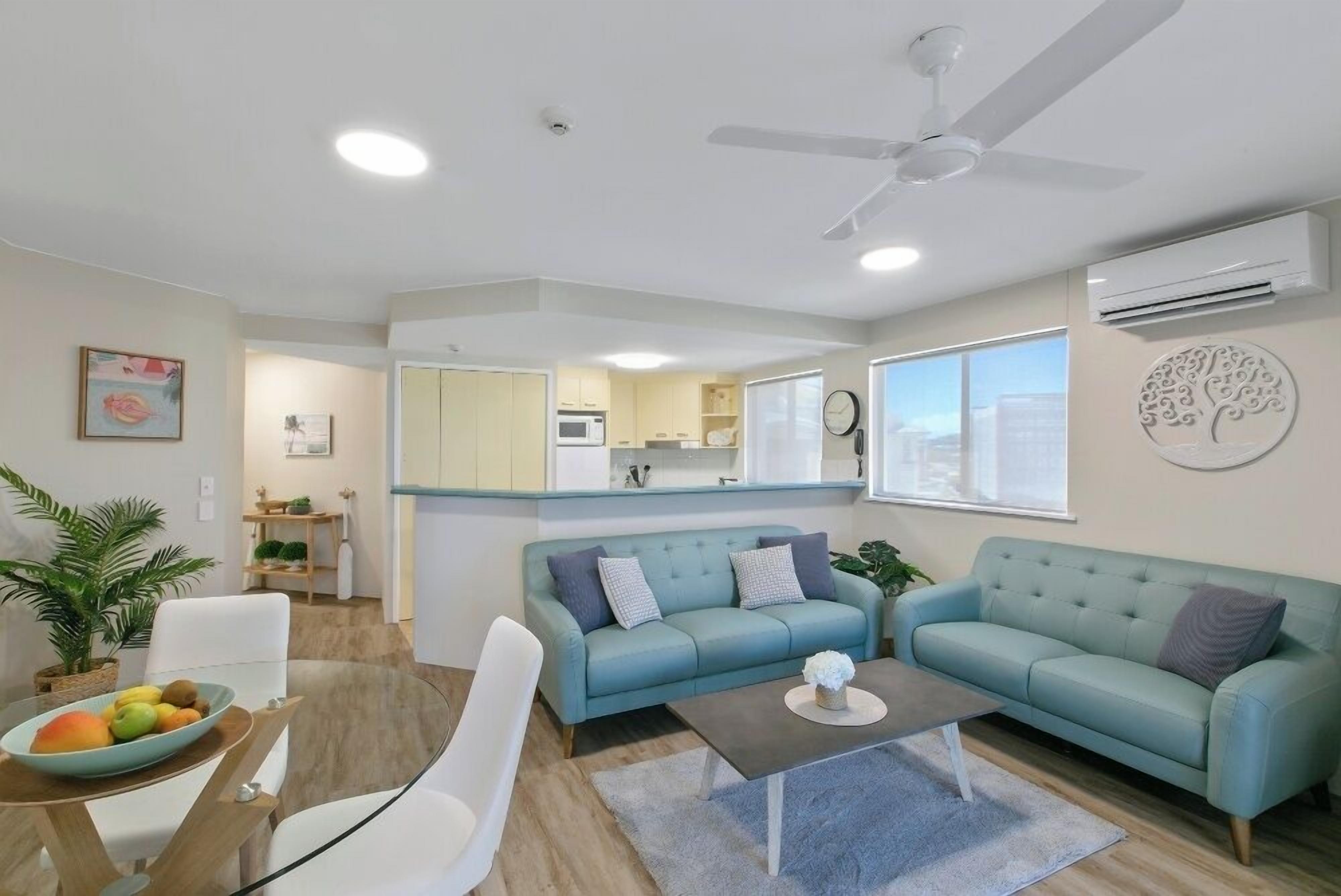 A modern living room with a sofa, coffee table, and dining area.