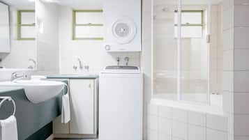 A modern bathroom with a large sink, a toilet, a shower, and a built-in dryer.