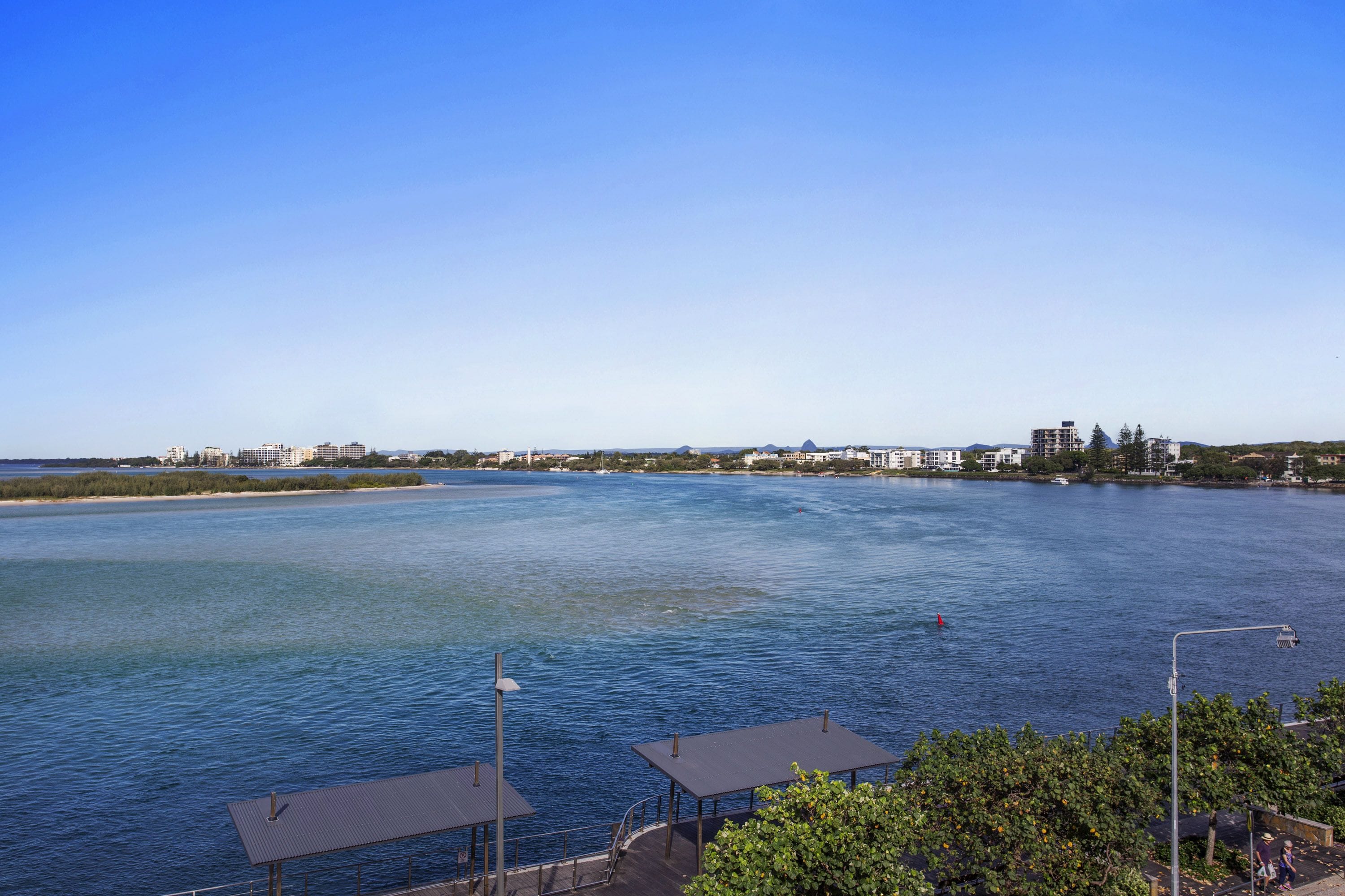 Vista al agua con muelle y edificios al fondo.