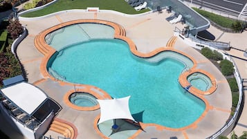Relax by the pool surrounded by seating areas and a curved glass barrier.