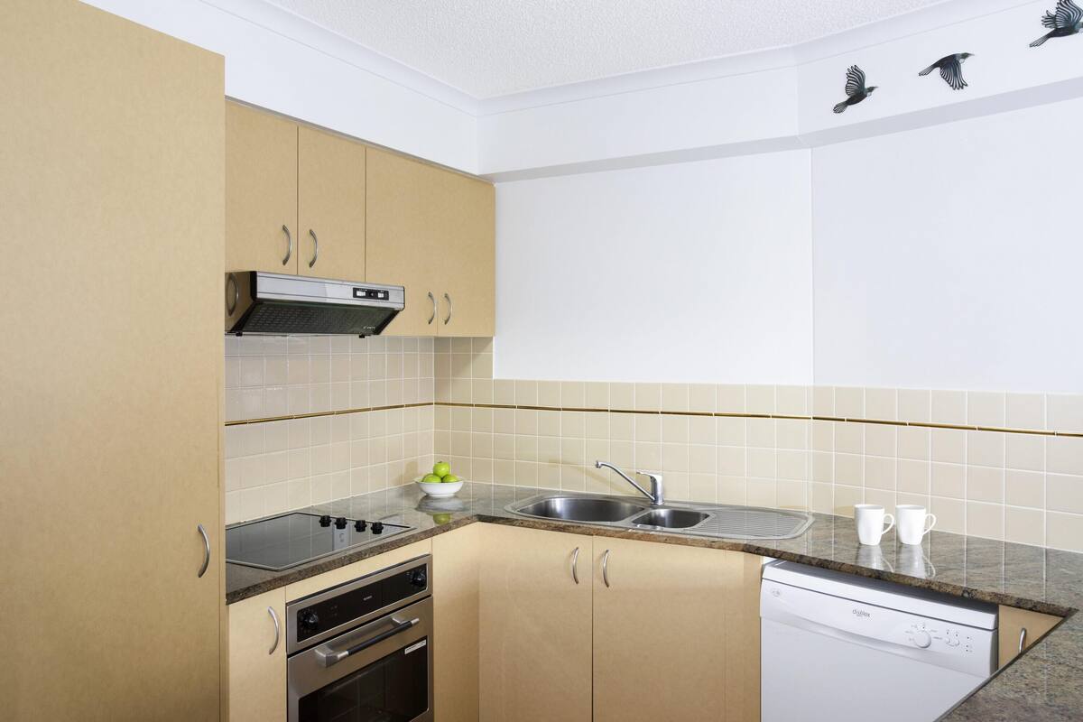 A compact kitchen with a dishwasher, oven, and a stove.