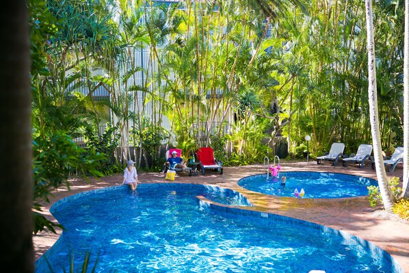 Una piscina al aire libre, tumbonas