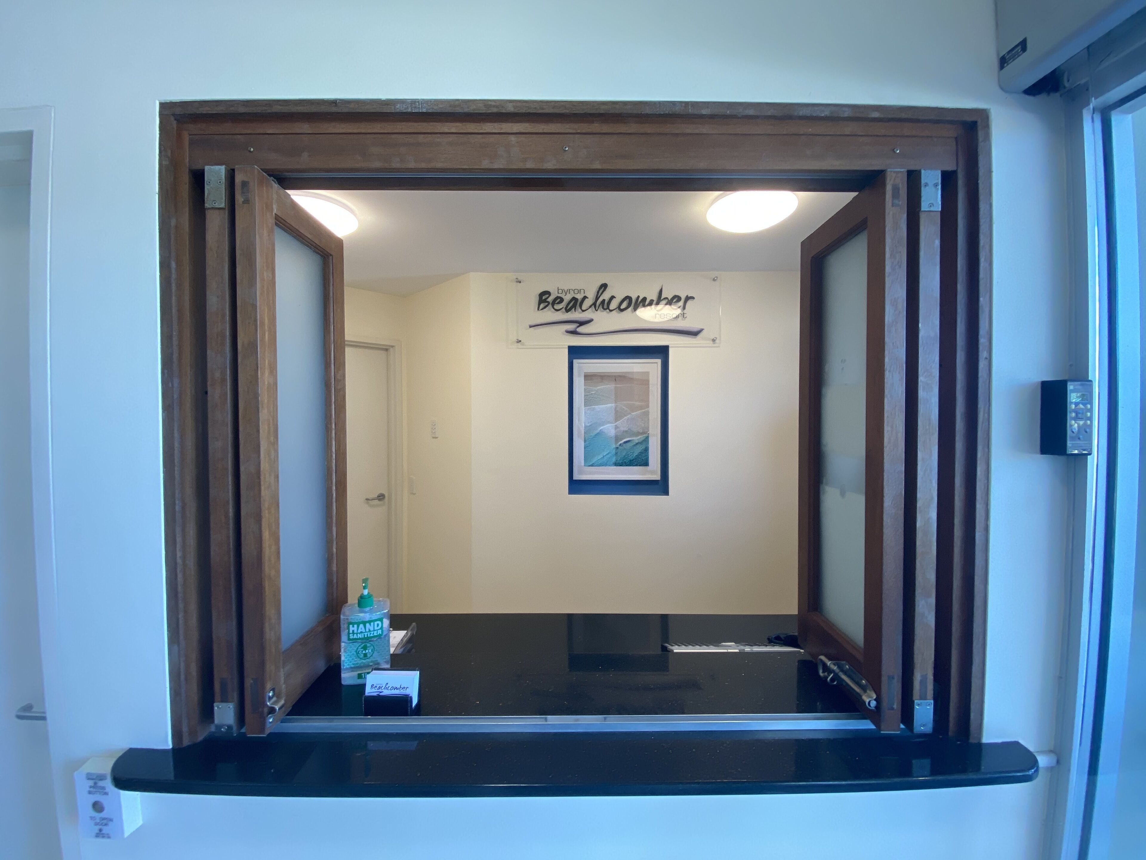 Una mesa de recepción con un cartel que dice 'Beachcomber Resort' y una foto enmarcada encima.