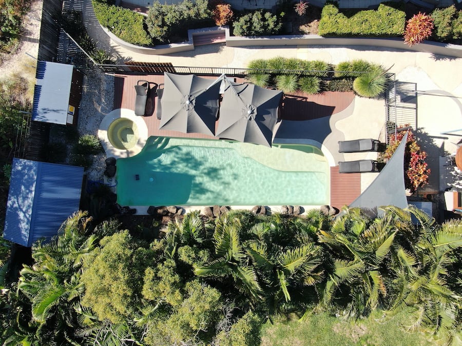 Een buitenzwembad, ligstoelen bij het zwembad