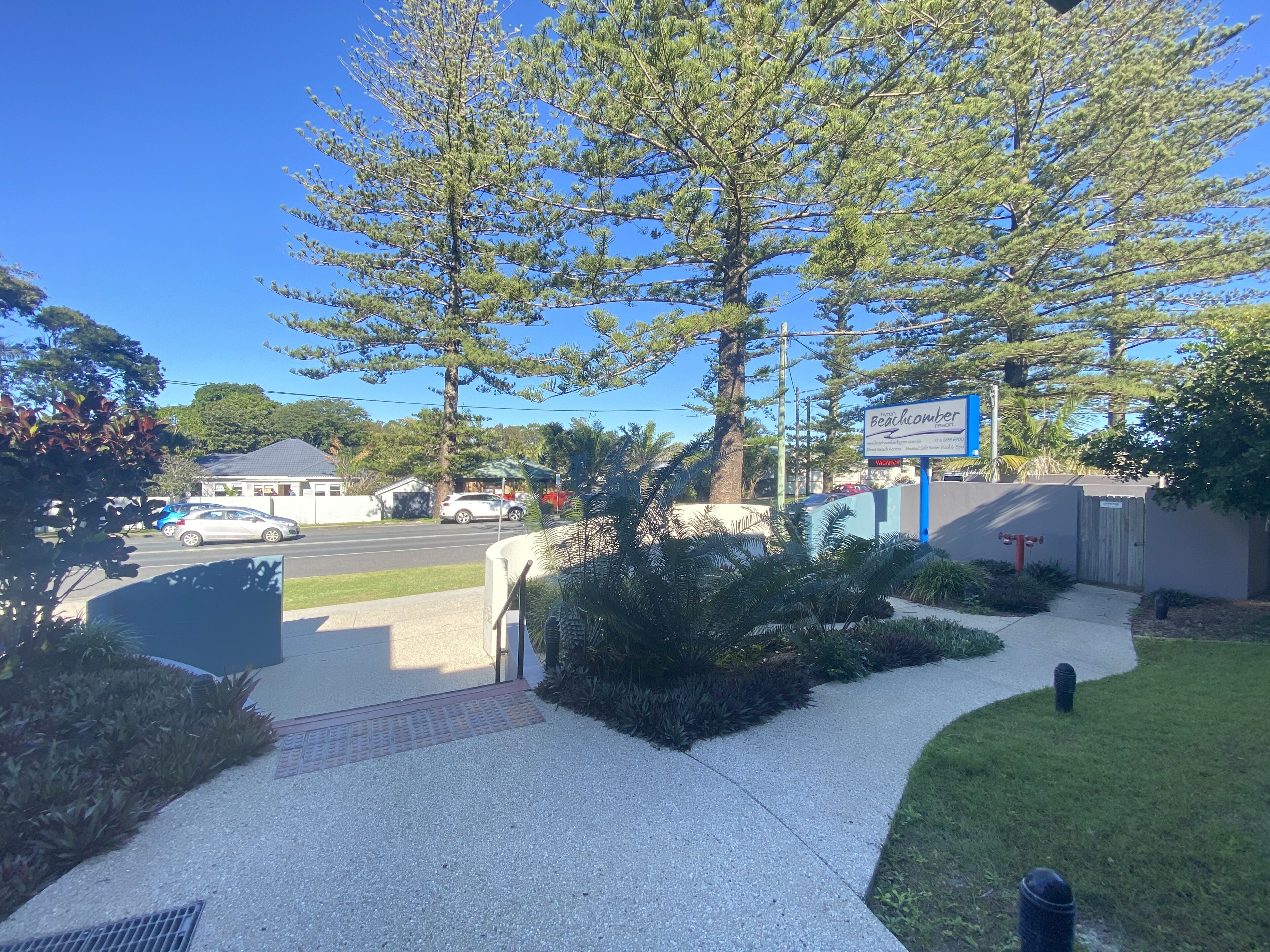 A commercial property with a large tree, a signboard, and a gated entrance.