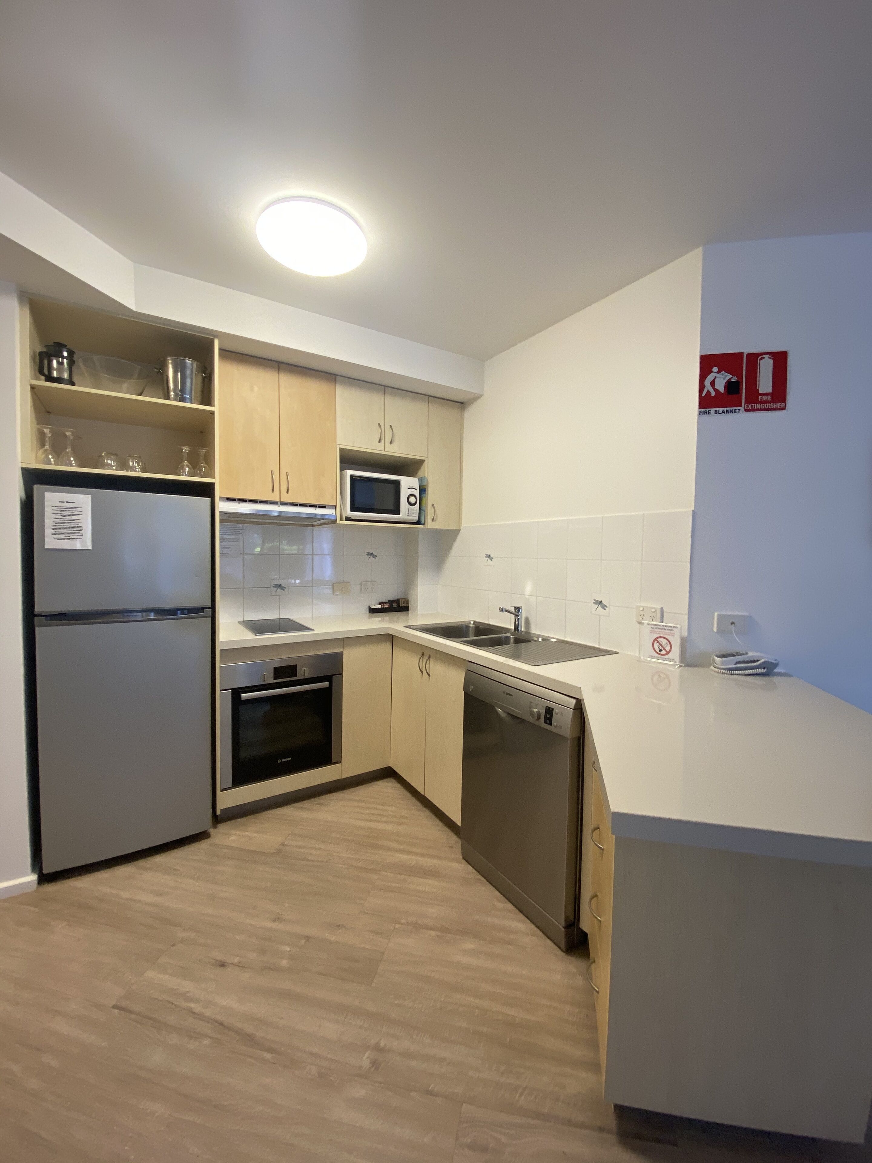 Una cocina moderna equipada con refrigerador, microondas, horno, lavavajillas y un lavabo.