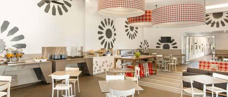 A modern dining area with white furniture, a central island, and decorative wall art.