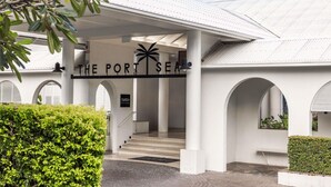 A building entrance with a sign reading 'THE PORT SEA' and a palm tree symbol. - Mantra PortSea (Port Douglas)