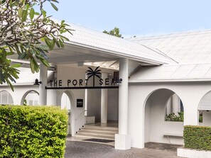 A building entrance with a sign reading 'THE PORT SEA' and a palm tree symbol. - Mantra PortSea (Port Douglas)