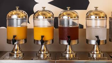 Cuatro dispensadores de bebidas con contenedores transparentes y tapas metálicas.