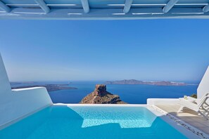 A clear blue sky, a pool, and a view of the sea and islands. - Astra Suites (Santorini)