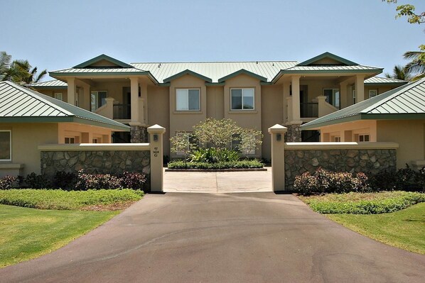 A two-story building with a central entrance, stone walls, and a landscaped garden.
