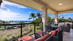A balcony with wicker furniture and a view of the ocean and golf course. - Kumulani at Mauna Kea (Kamuela)