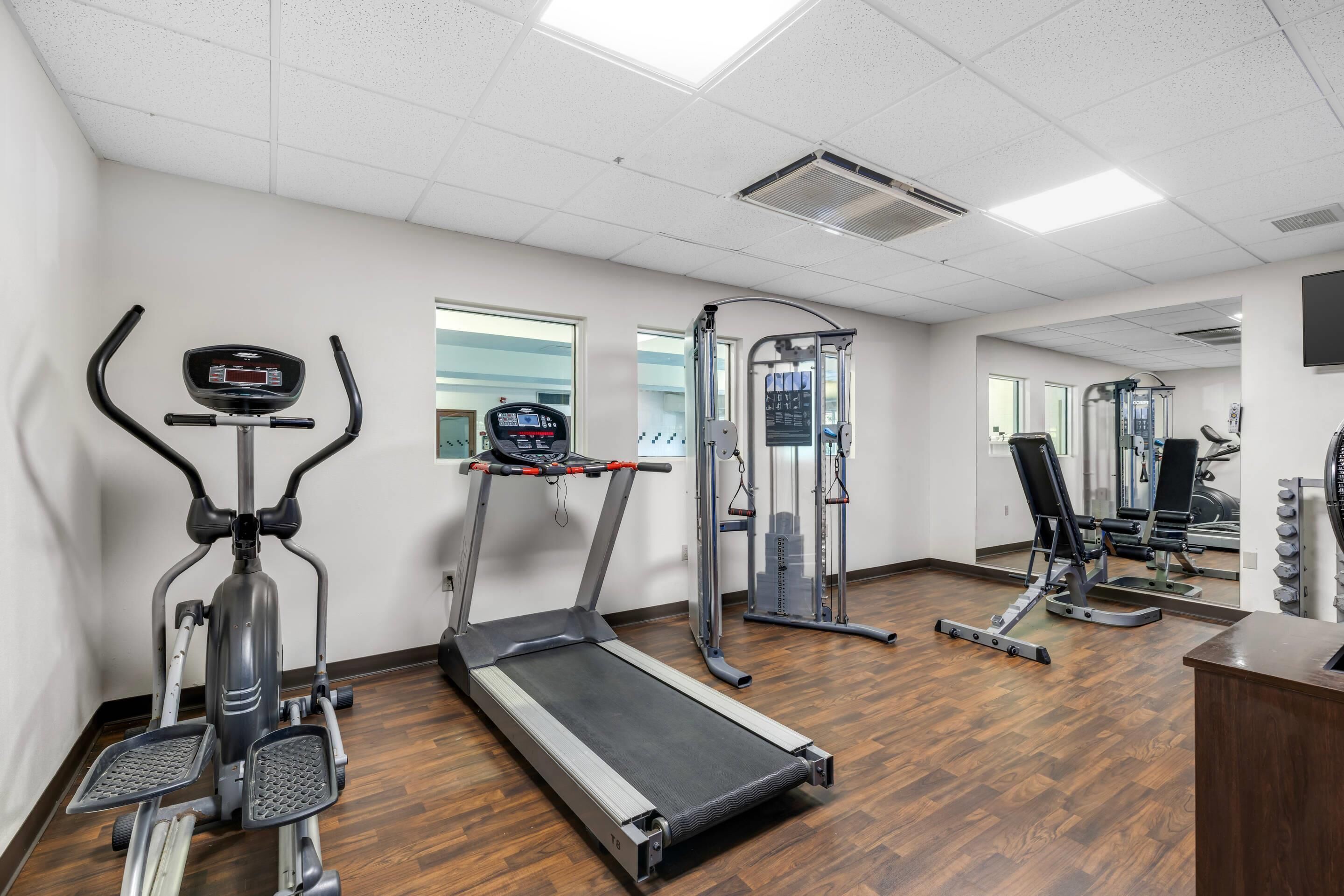 A gym with treadmills, an elliptical, and a weight machine.