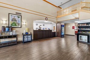 A hotel lobby with a reception desk, a clock, a vending machine, and a Marketplace.