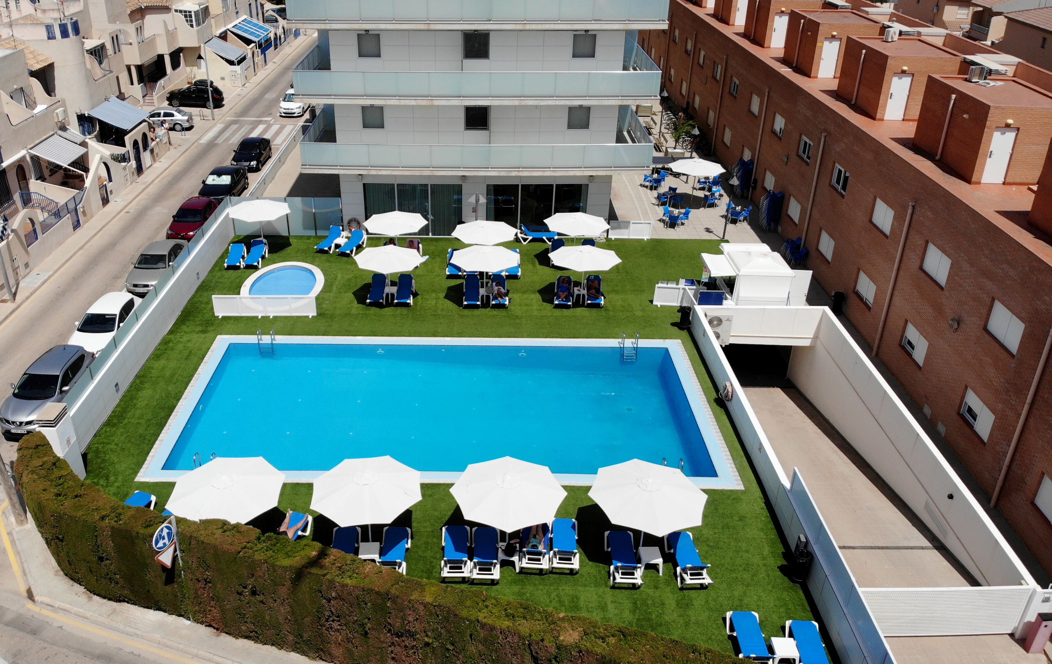 Una piscina al aire libre de temporada, sombrillas