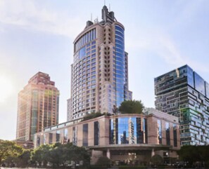 Un immeuble moderne de grande hauteur, doté d’une façade incurvée et de nombreux étages.