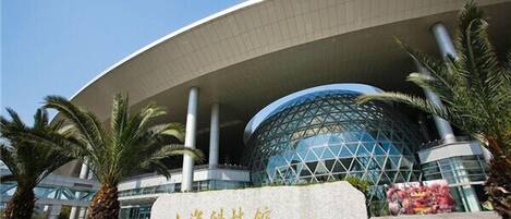 A modern building with a curved facade and a large glass dome structure.