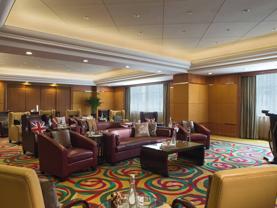 A spacious lobby with leather sofas, a coffee table, and a patterned carpet.