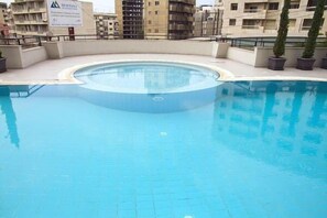 Piscine extérieure, parasols de plage, chaises longues