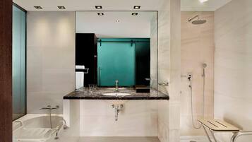 Une salle de bain moderne comprenant une baignoire, un lavabo avec un meuble-vasque, un miroir et un espace douche.