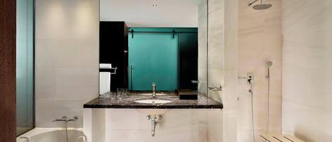 A modern bathroom with a bathtub, a sink with a vanity, a mirror, and a shower area.