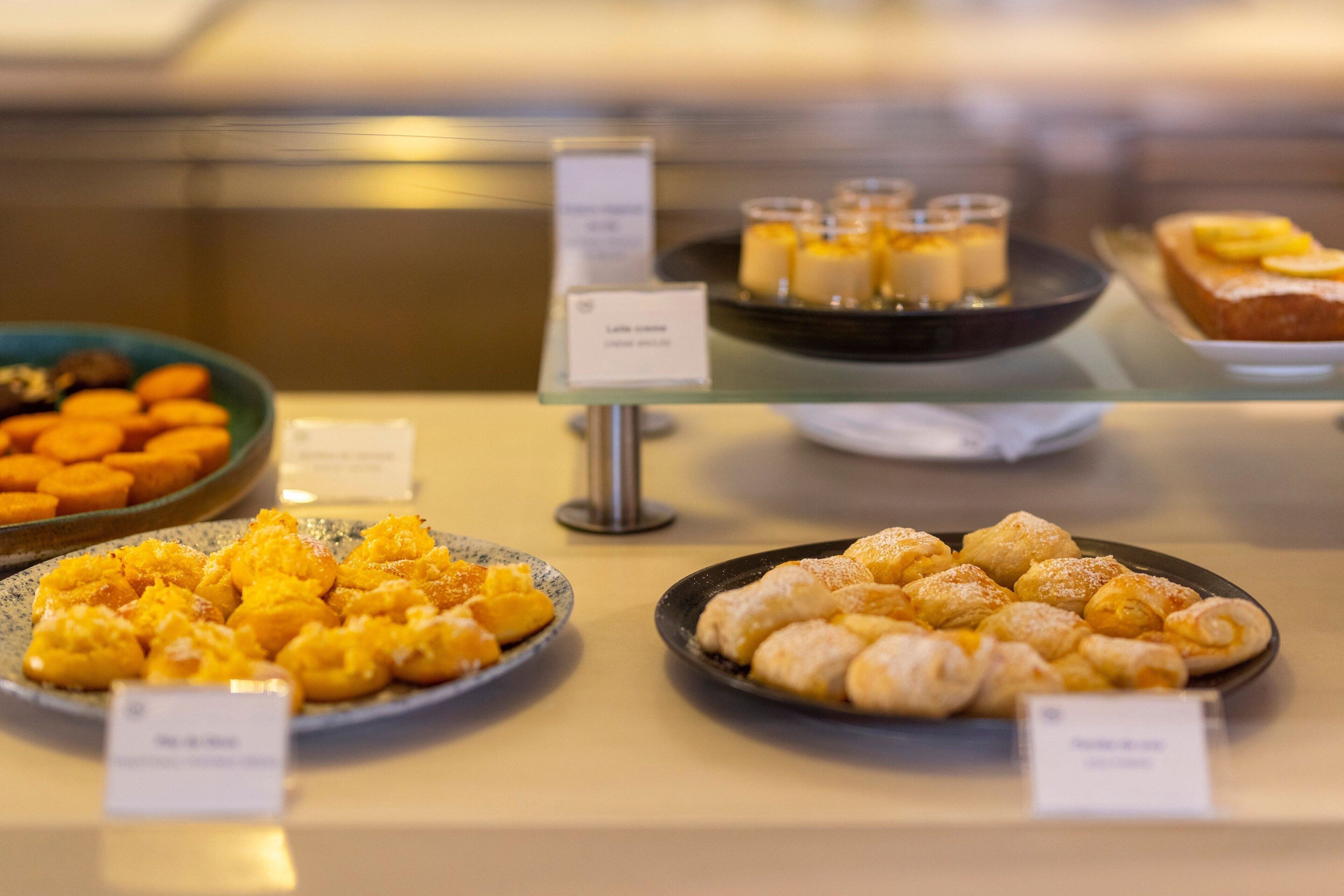 Una vitrina con diversos postres, incluyendo pasteles y crema pastelera.