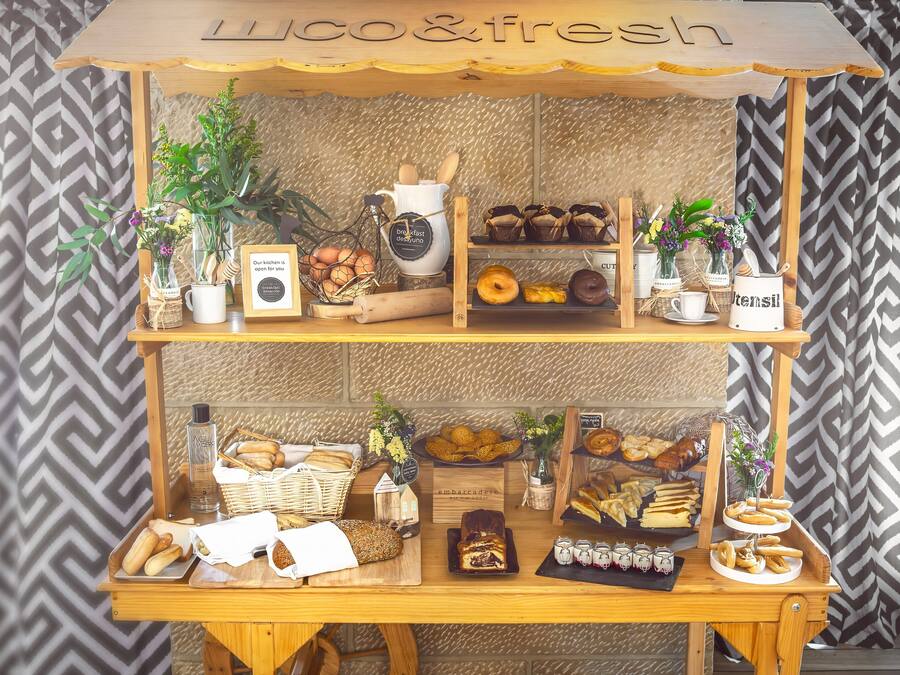 Una vitrina de pastelería con diversos productos horneados y flores frescas.